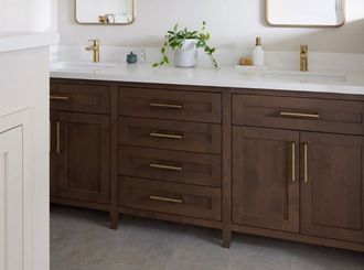 Bright bathroom vanity with two gold-framed mirrors, white countertop, and dark wood cabinets.