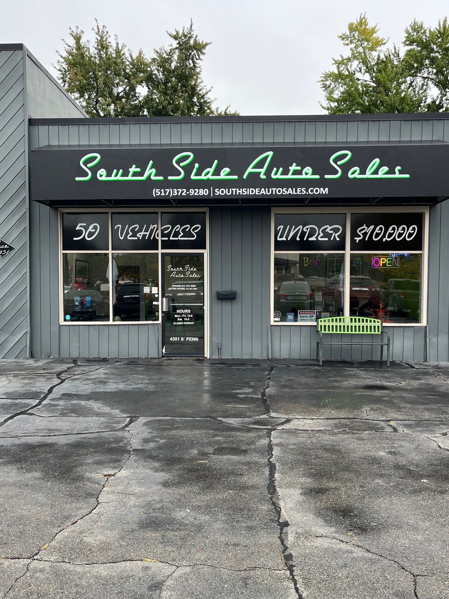South Side Auto Sales storefront with green script sign, car price windows, and a cracked parking lot