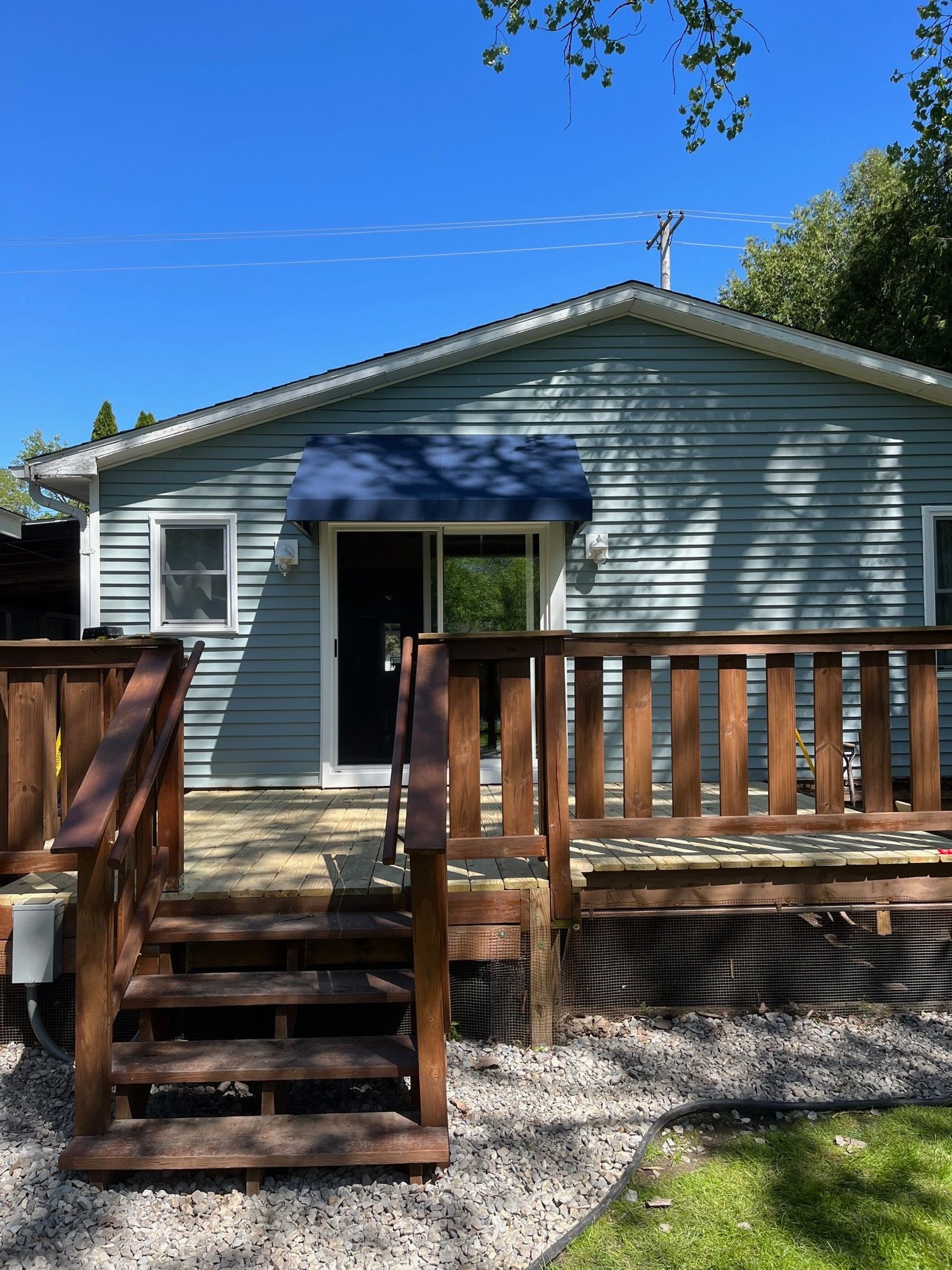 A house with a wooden deck and stairs in front of it.