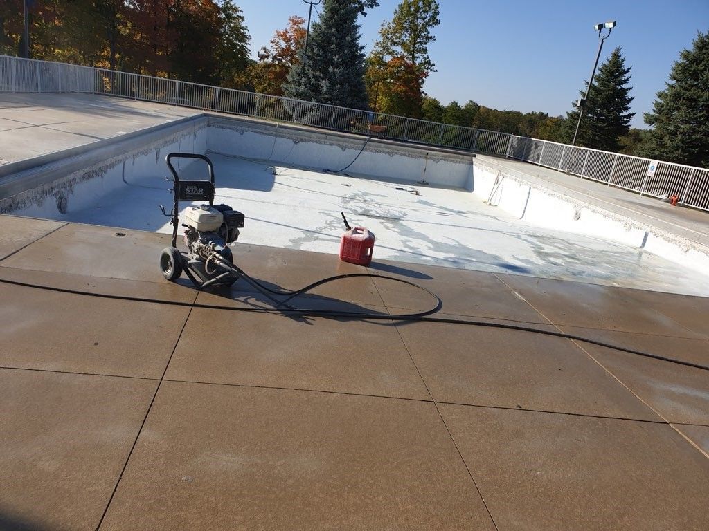 A swimming pool with no water is being stripped for resurfacing