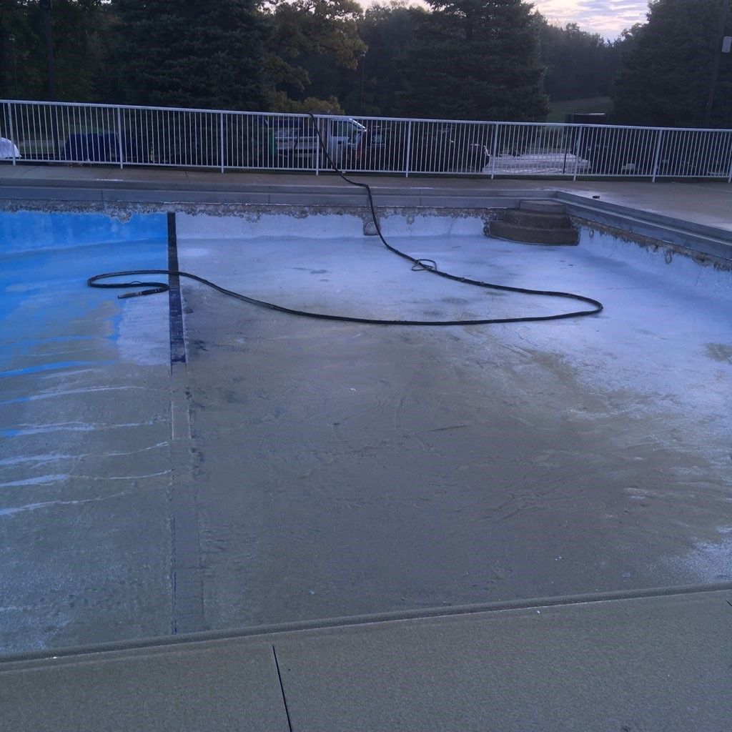 An empty swimming pool with a hose on it