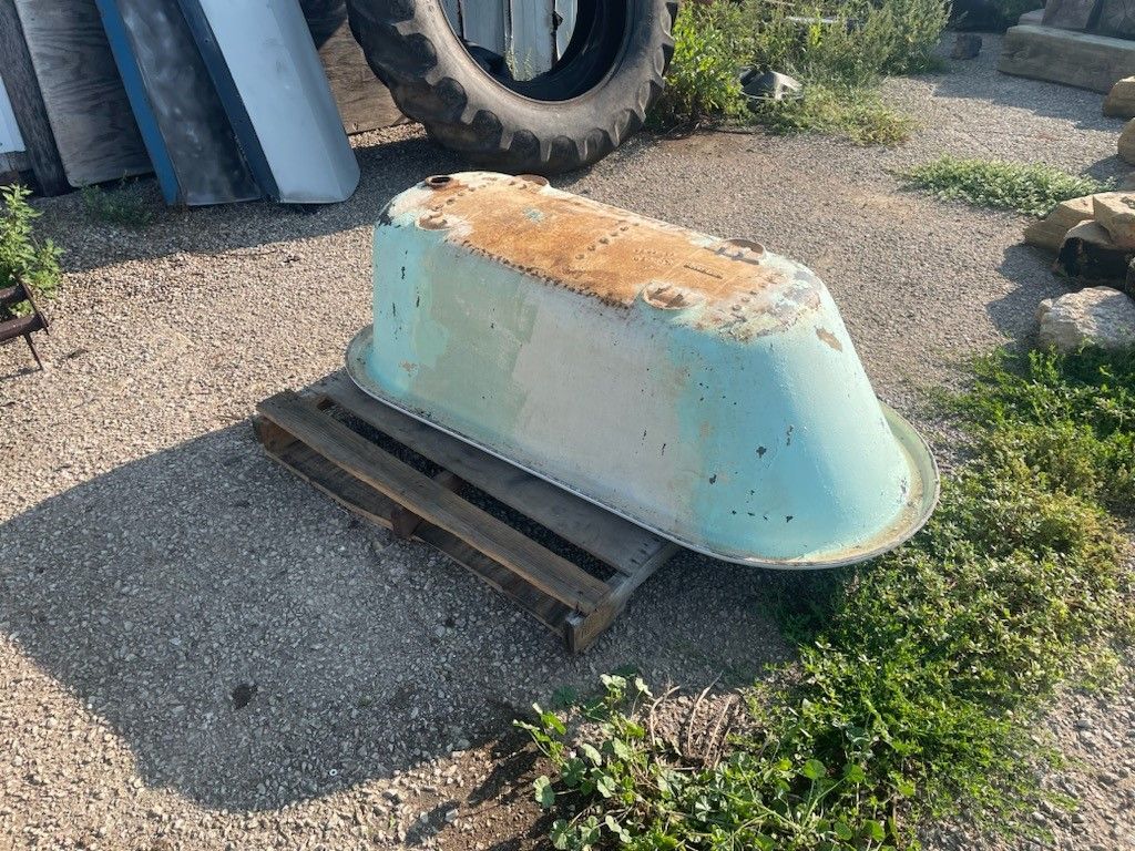 A blue bathtub is sitting on top of a wooden pallet.