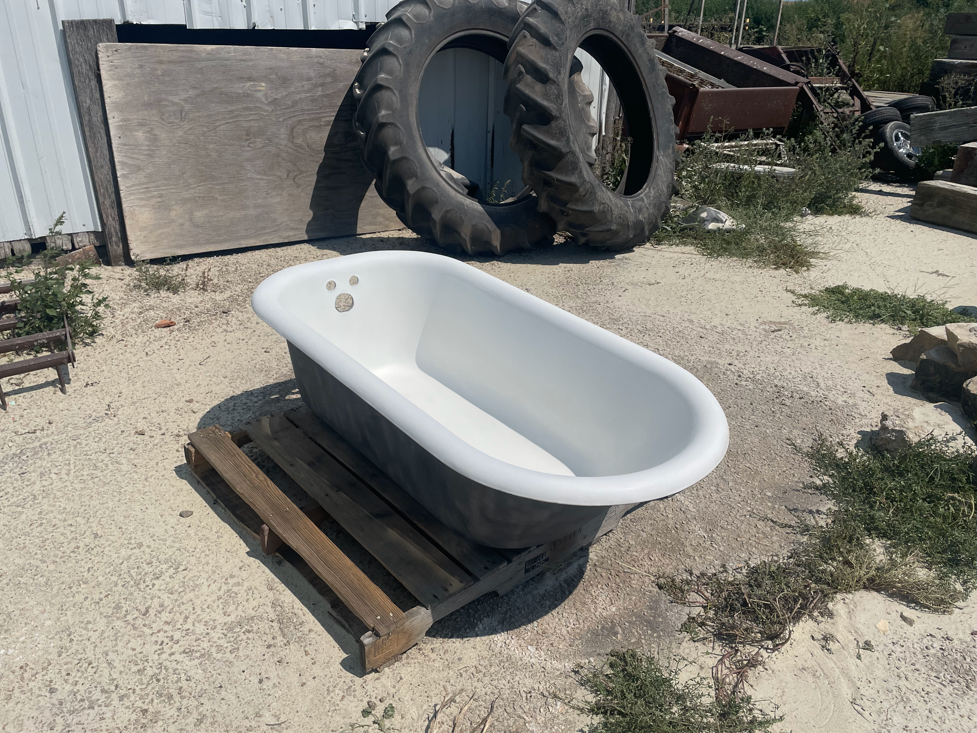 A white bathtub is sitting on a wooden pallet
