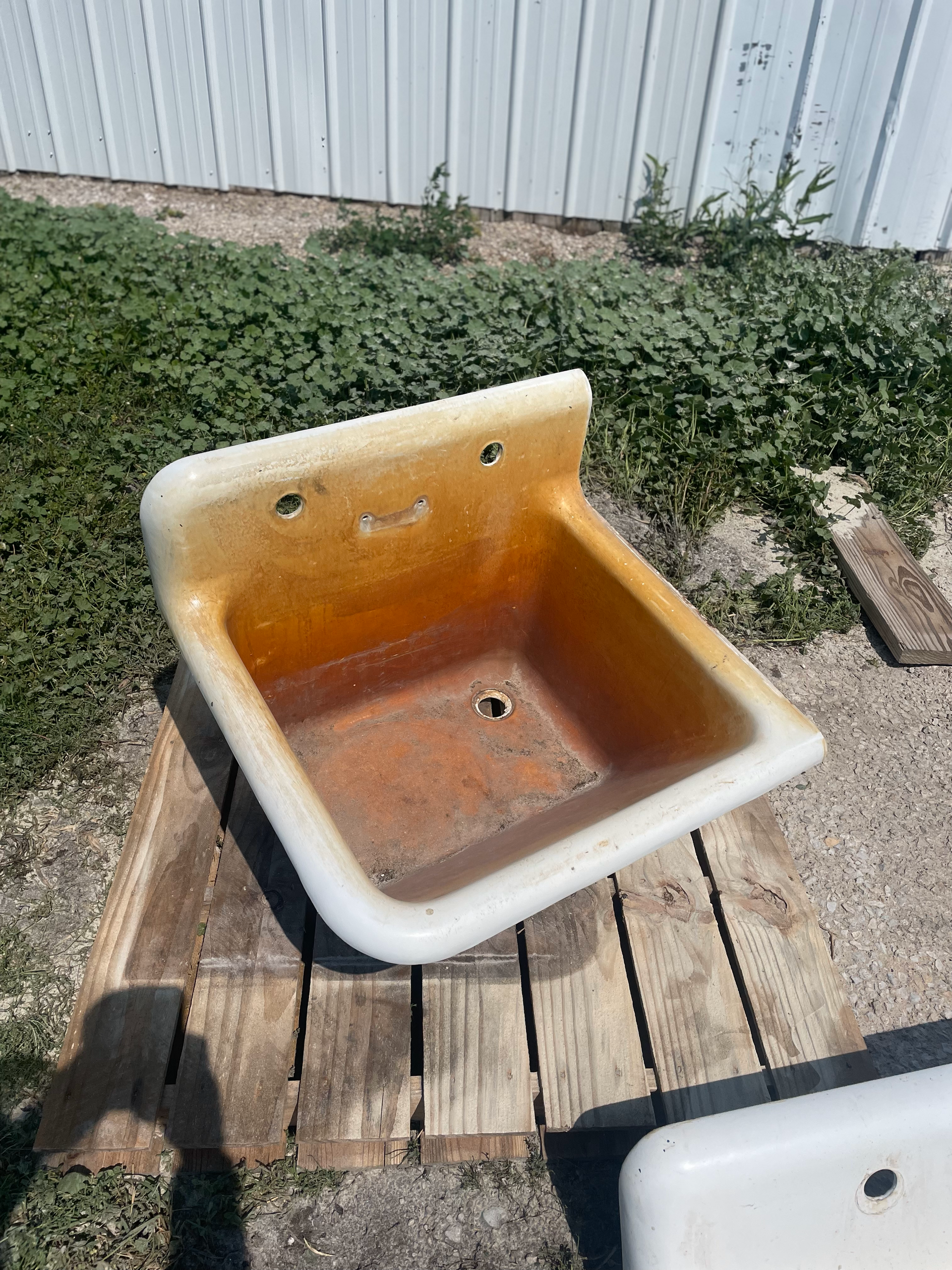 An old sink is sitting on top of a wooden table.