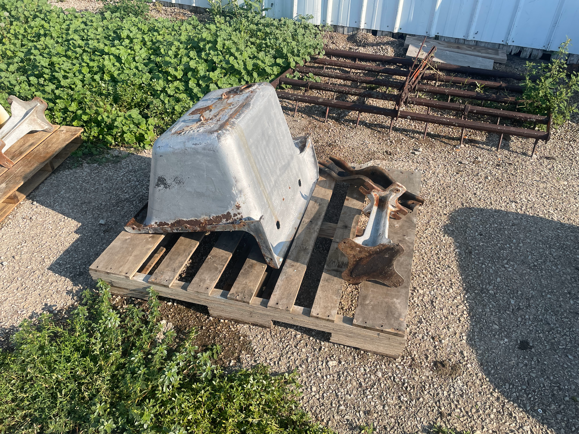 A piece of metal is sitting on top of a wooden pallet.