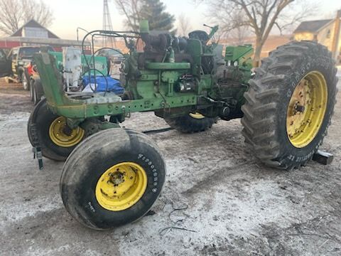 a green and yellow john deere tractor is parked