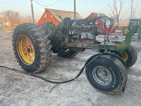 a john deere tractor is parked in front of a barn