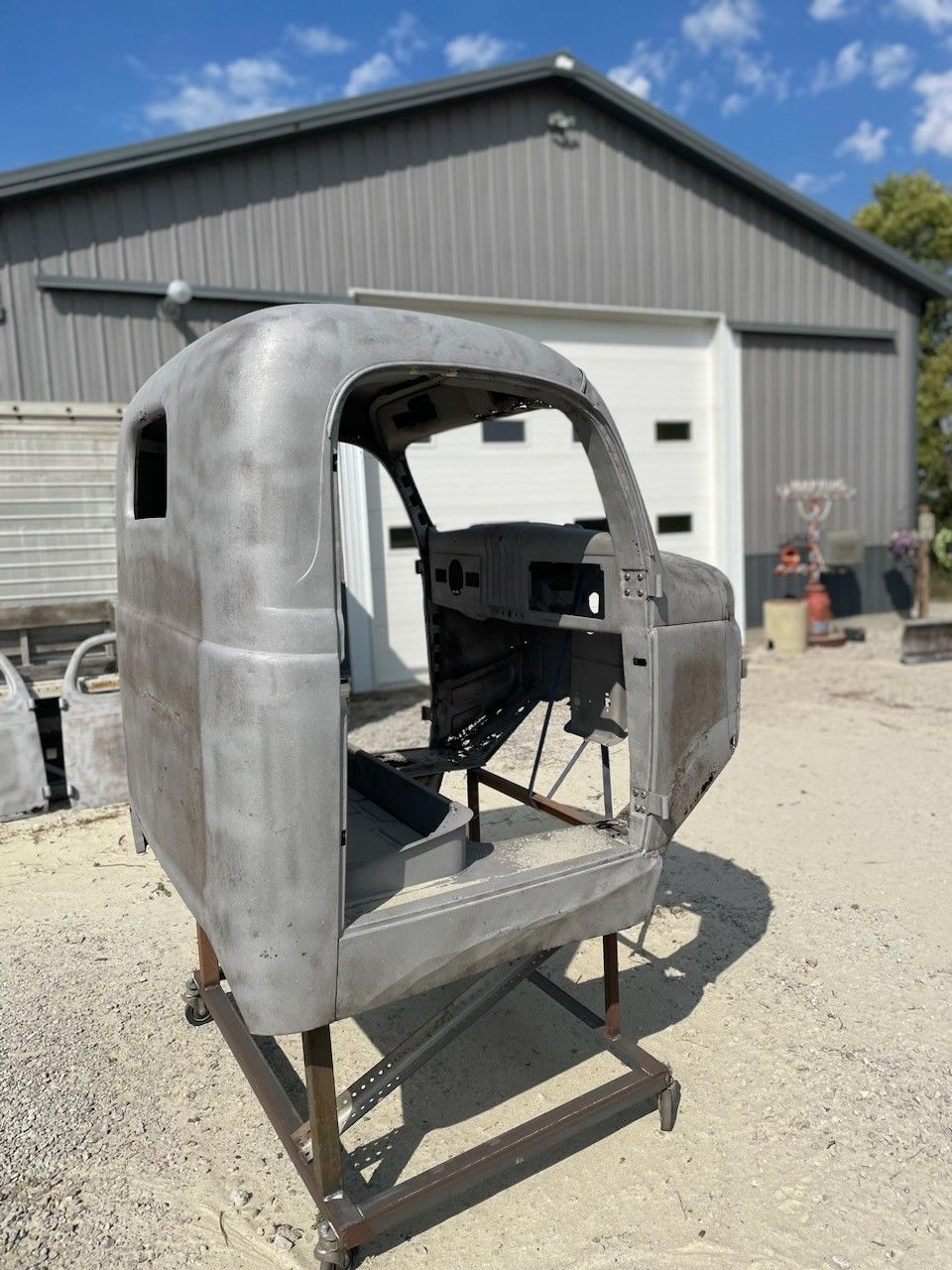 a red and white truck is sitting in front of a garage