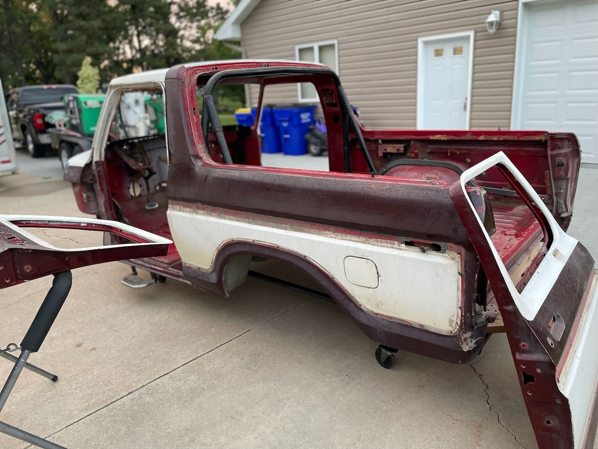 a red and white truck is sitting in front of a garage