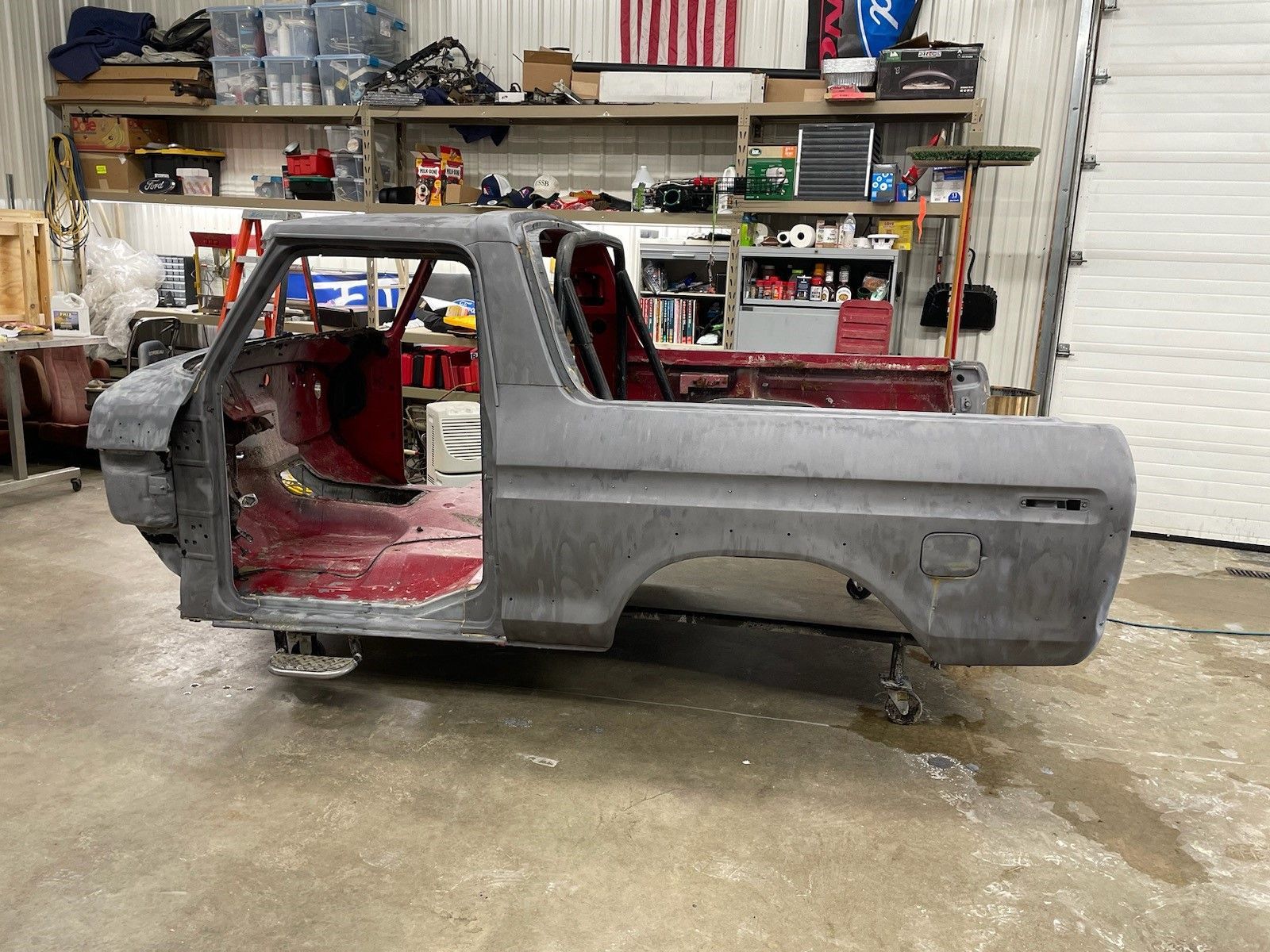 a gray truck is sitting in a garage with the door open