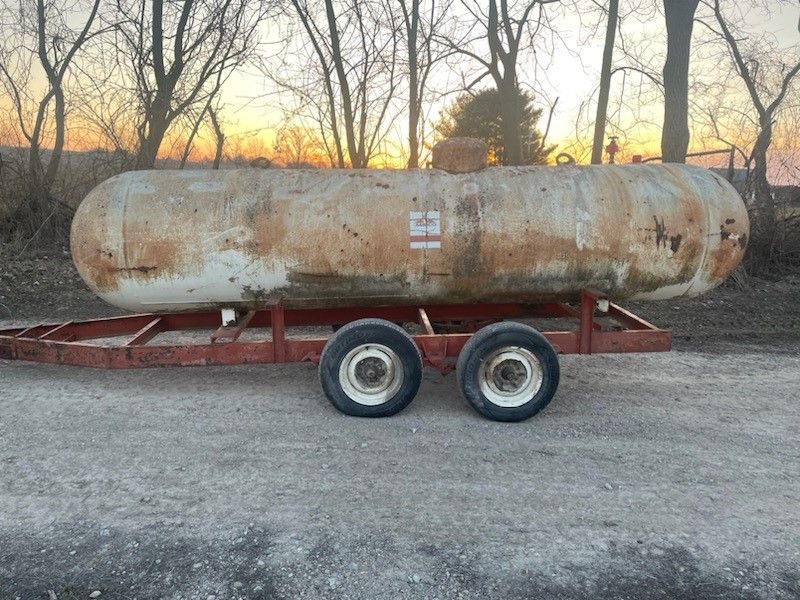 a large rusty propane tank is sitting on a trailer