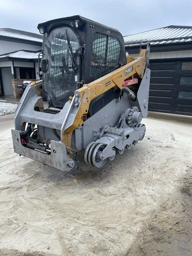 A bulldozer is parked in the dirt in front of a house