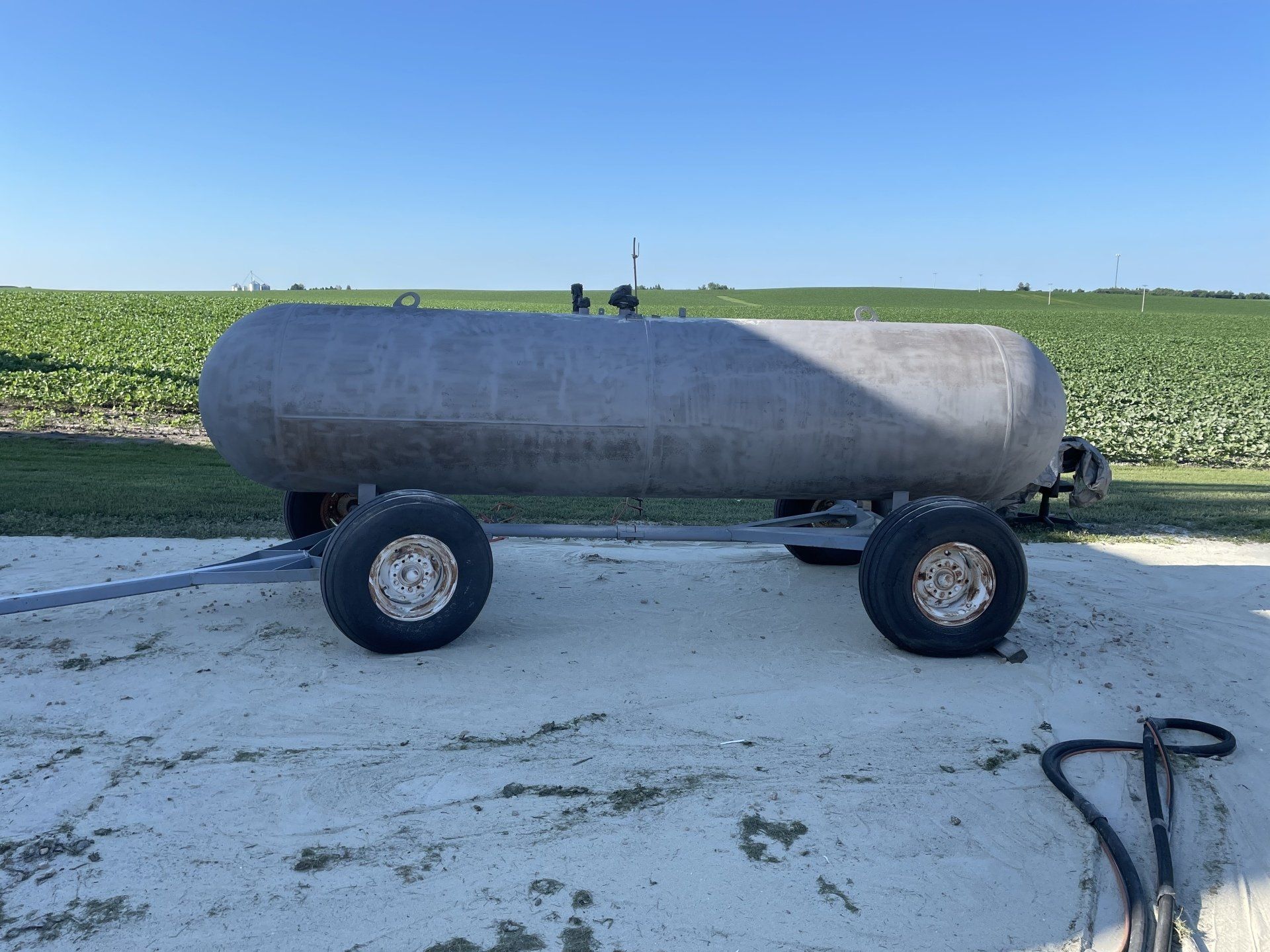 a large tank is sitting on a trailer in a field