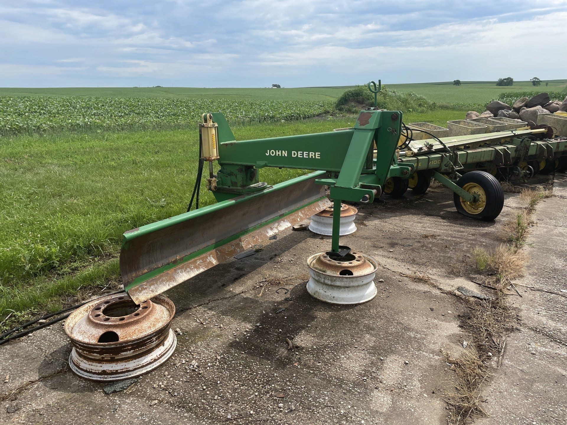 a green tractor is parked on the side of the road next to a field