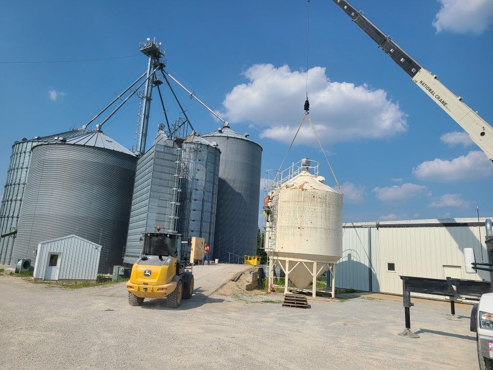 a crane is lifting a silo