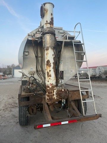 The back of a tanker truck with a ladder attached to it