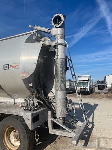 The back of a tanker truck with a ladder attached to it