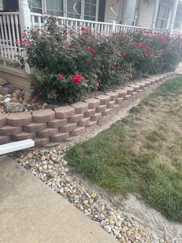 a concrete walkway leading to a house with a white picket fence