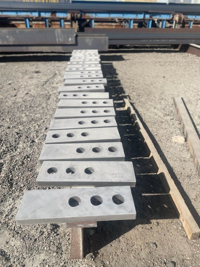 a row of steel plates with holes in them