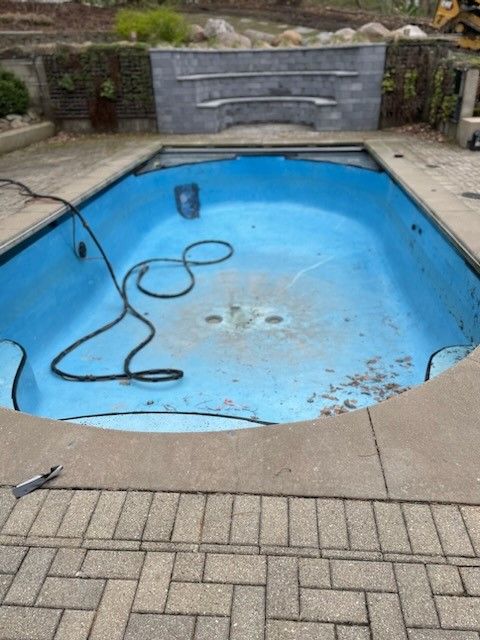 An empty swimming pool with a hose attached to it