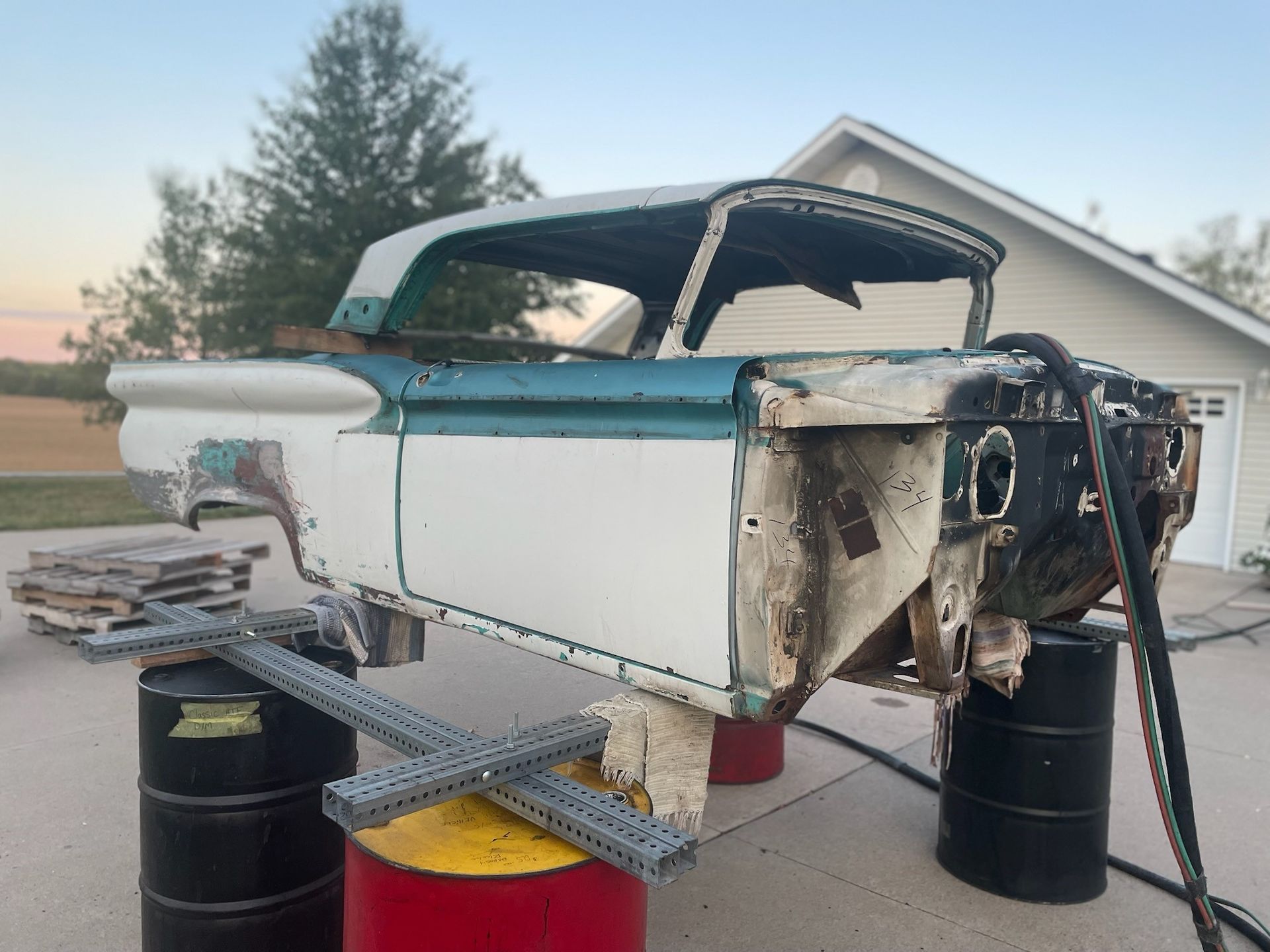 a white car is sitting on top of a red barrel
