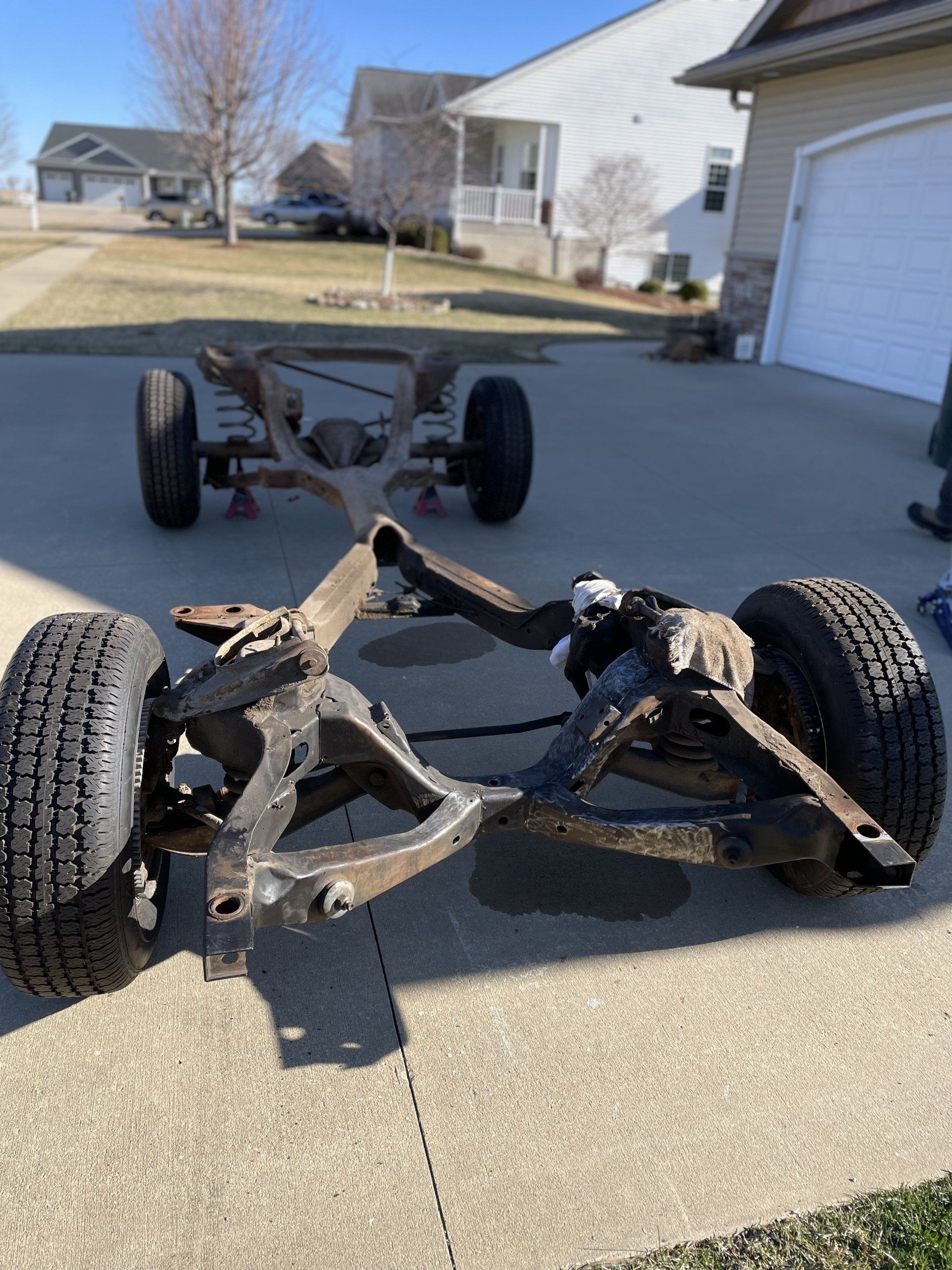 a car frame is sitting on the sidewalk in front of a garage