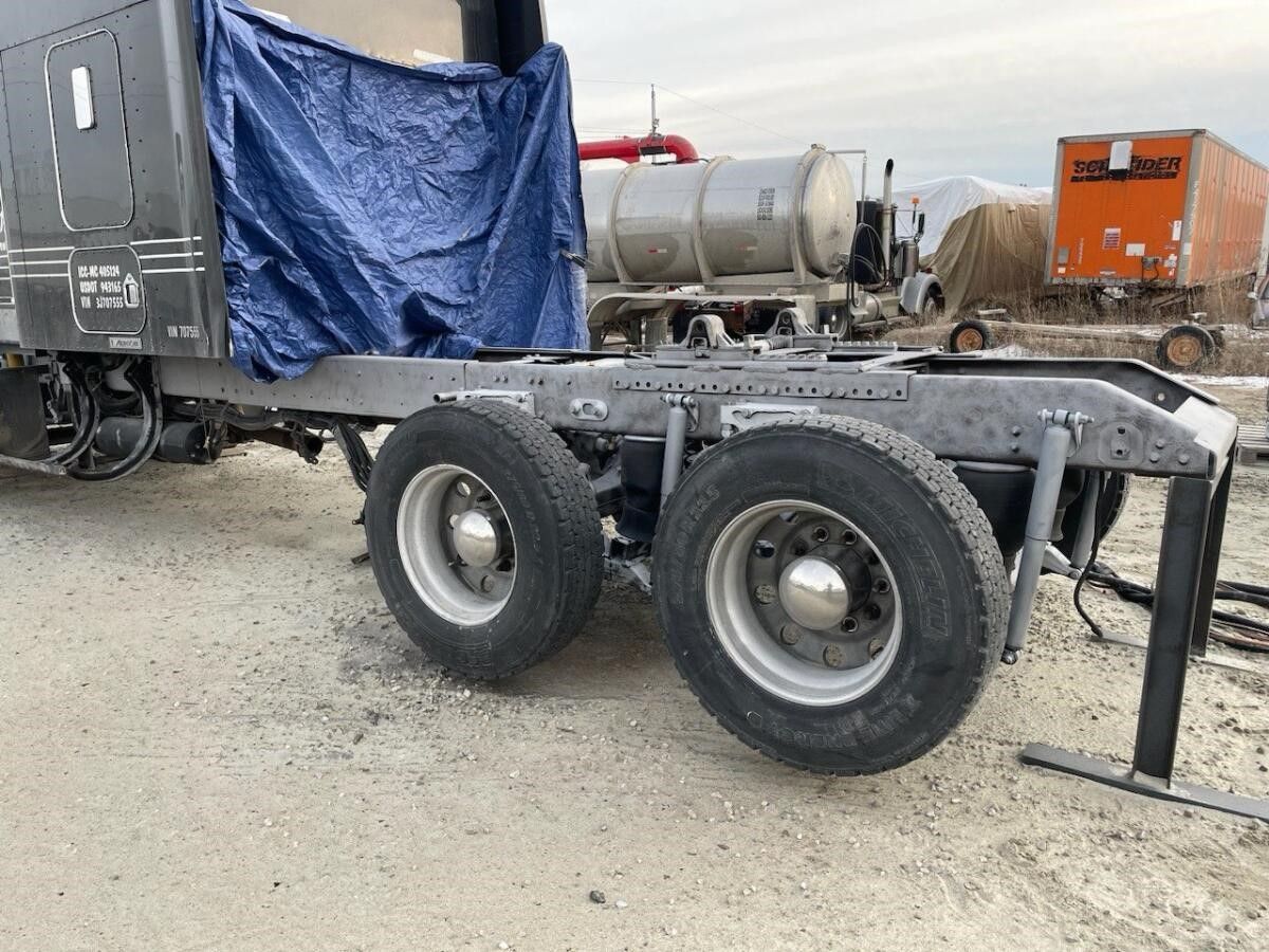 a semi truck is parked with a blue tarp covering it