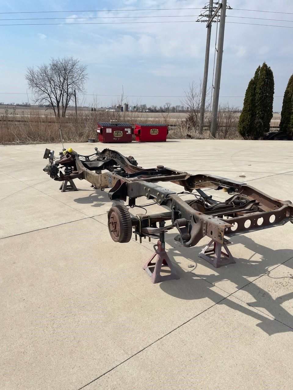 a truck chassis is sitting on jack stands on the side of the road