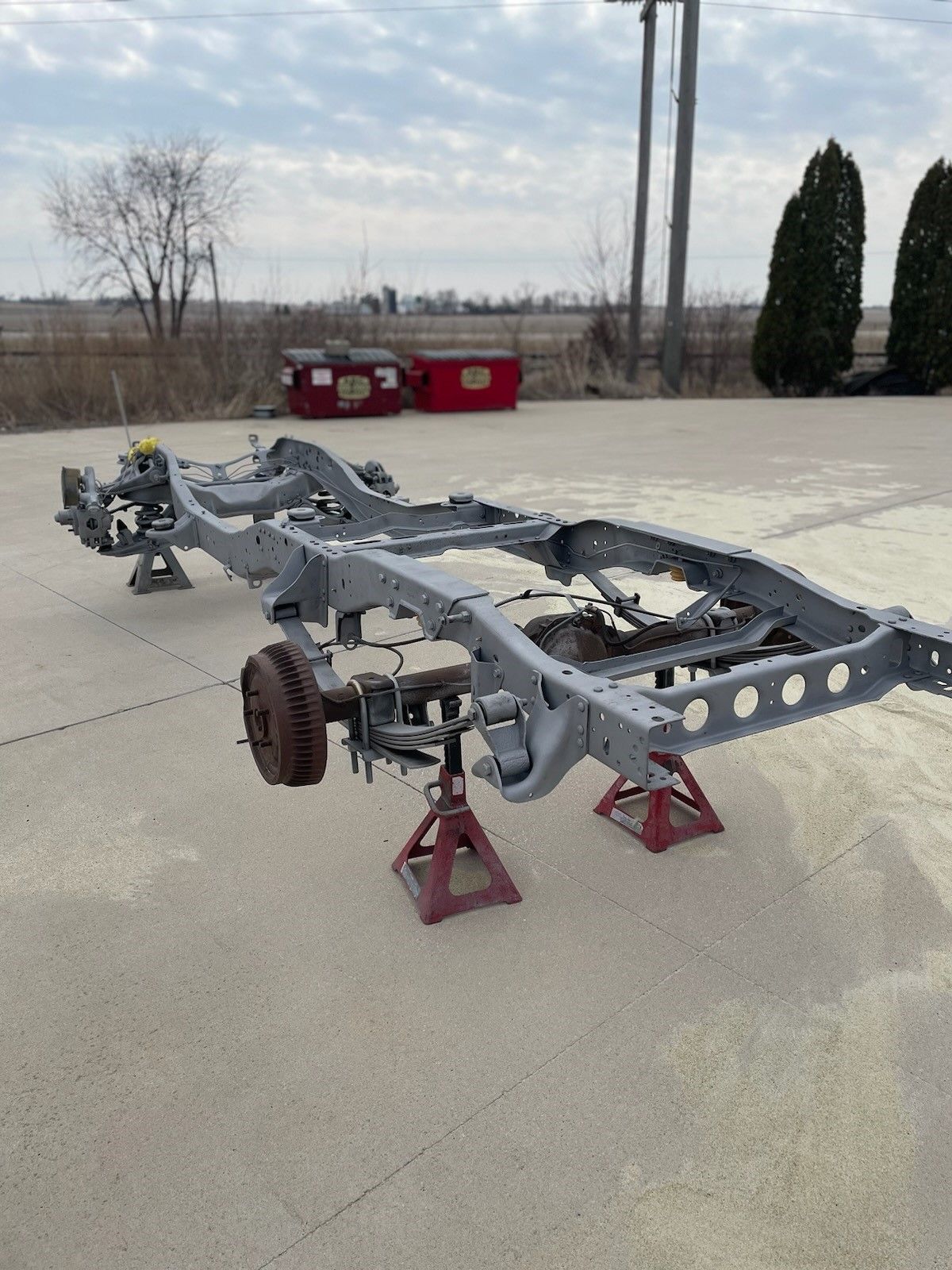 a truck chassis is sitting on jack stands on the side of the road