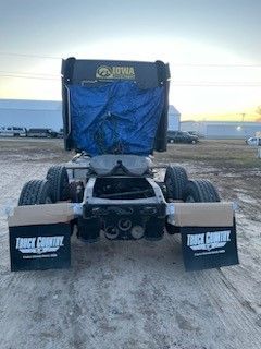 A semi truck is parked in a dirt field.
