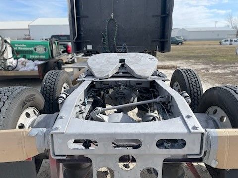 A semi truck with a trailer attached to it is parked in a field.