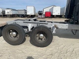 A semi truck with a trailer attached to it is parked in a lot.