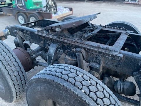 A semi truck with a trailer attached to it is sitting on the ground.