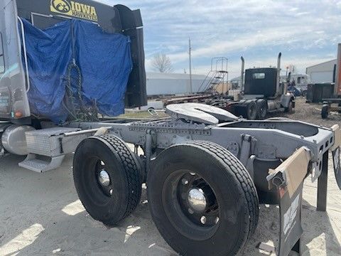A semi truck with a trailer attached to it is parked in a lot.