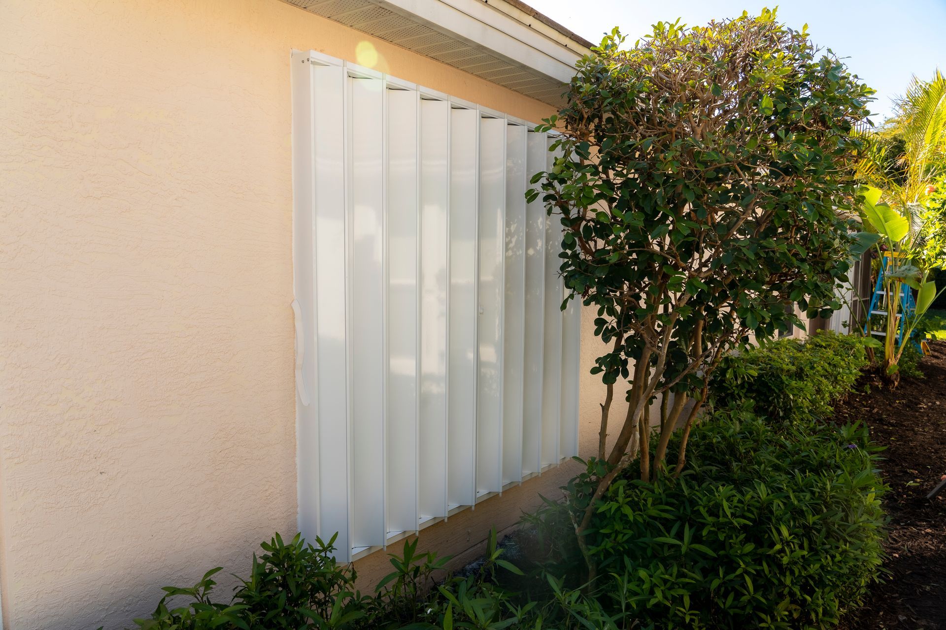White accordion shutters closed on a window