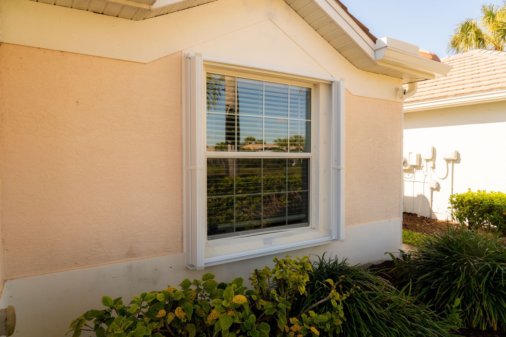 White accordion shutters open on a window