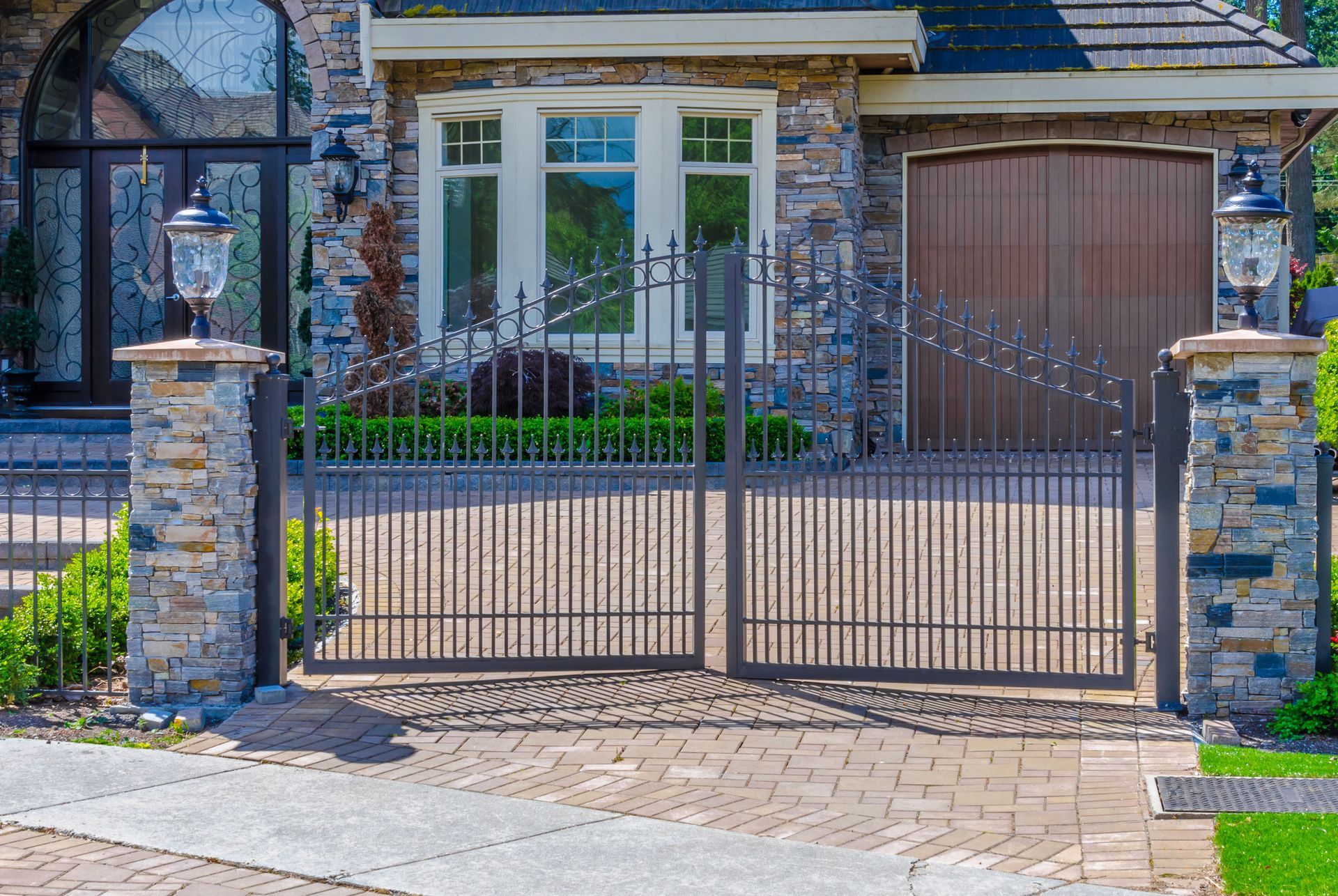 A large stone house with a wrought iron gate in front of it.