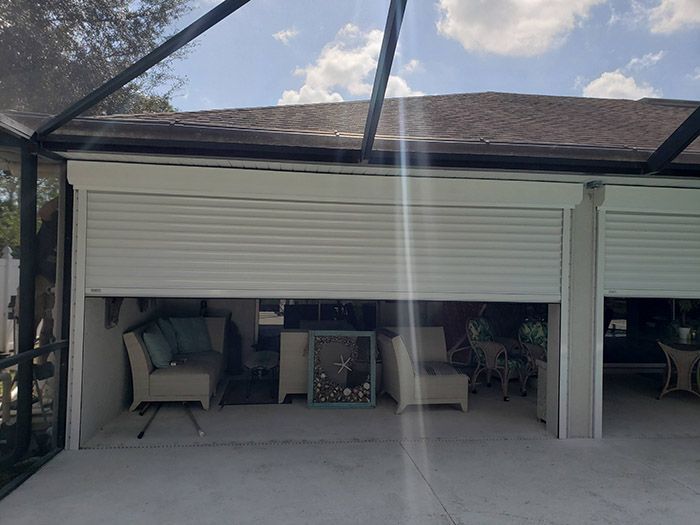 Exterior view of a patio with partially open roll-down shutters.