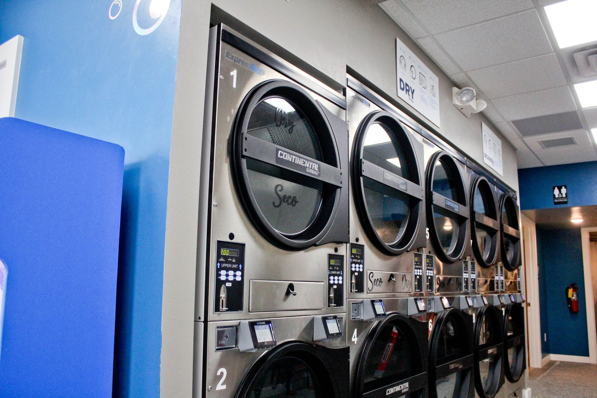 a row of washing machines are lined up in a laundromat