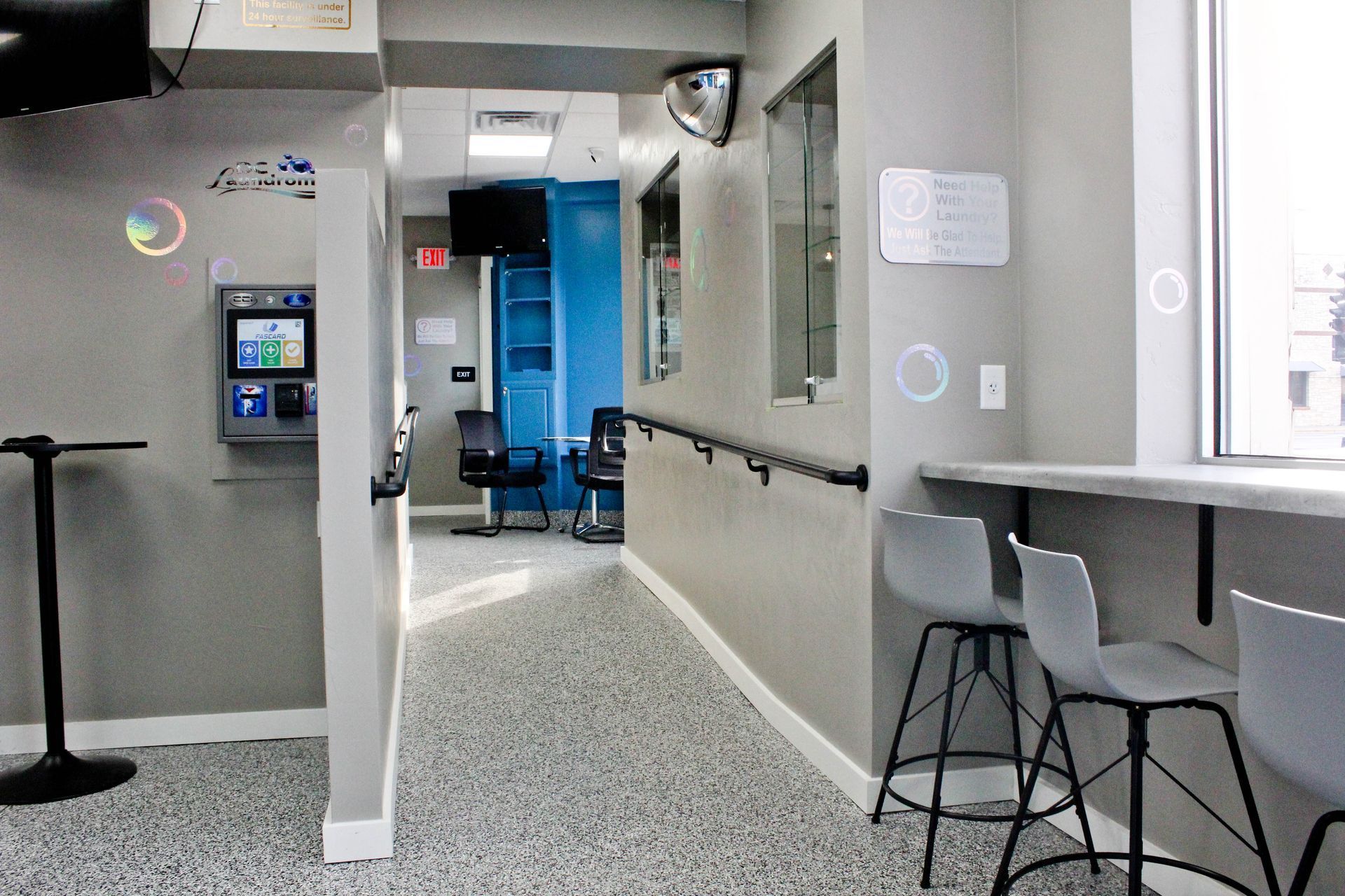 a hallway in a building with stools and tables