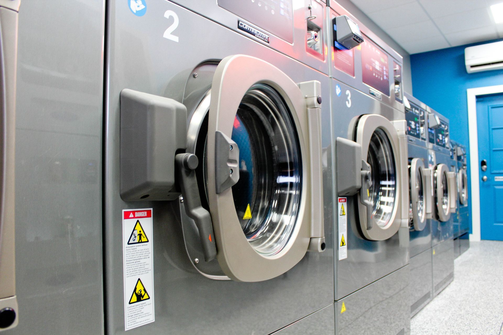 a row of washing machines are lined up in a laundromat