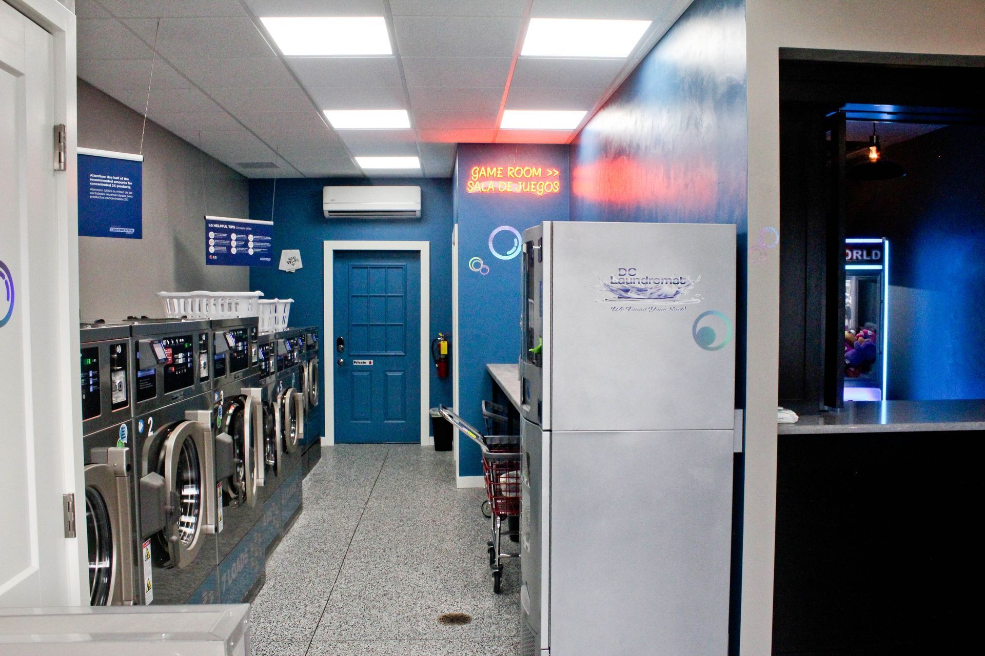 a laundromat with a refrigerator in the middle of the room