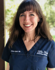 Smiling person in navy scrubs with