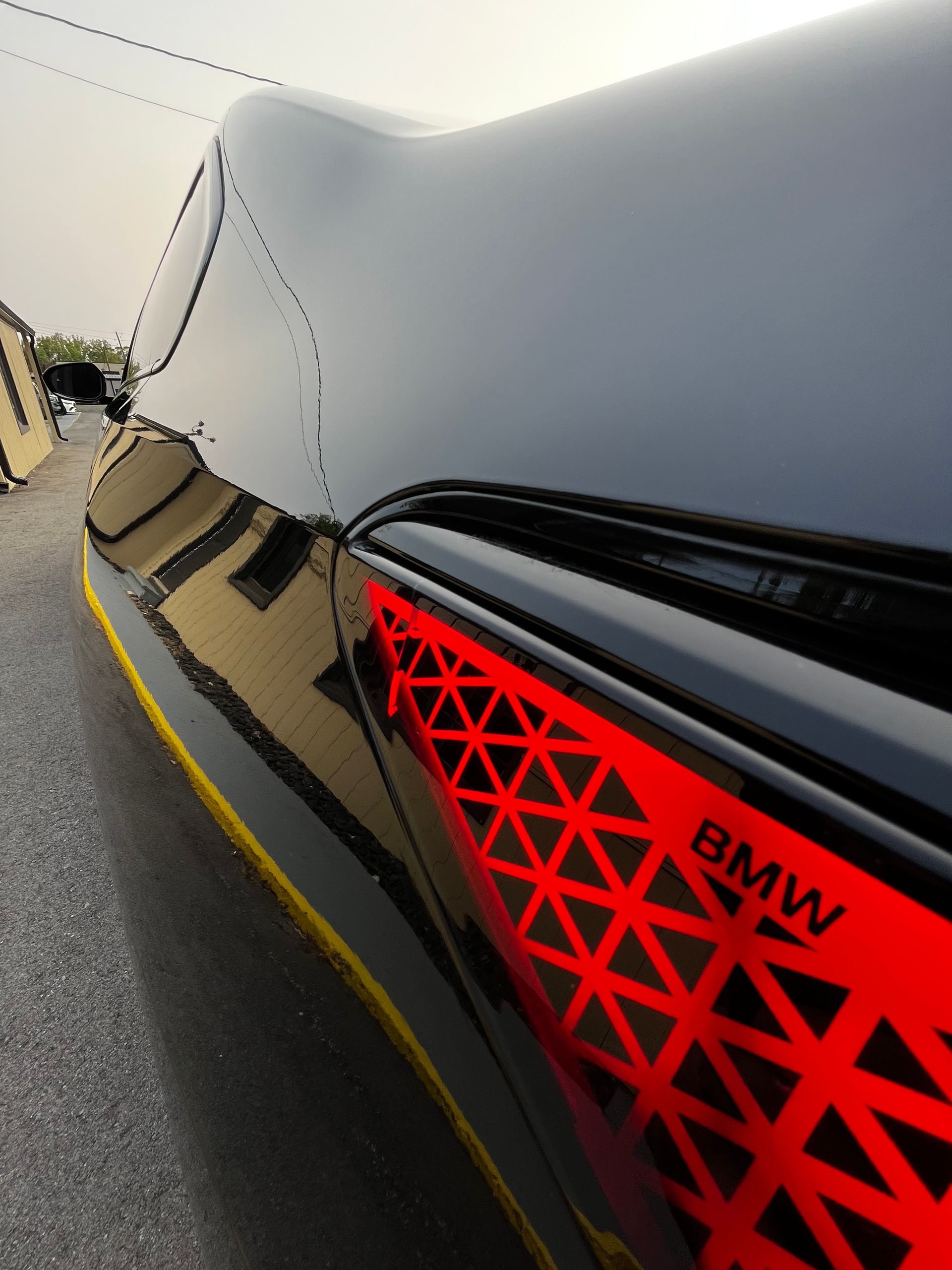Close-up of a black BMW car featuring a prominent red triangular geometric pattern on the side panel.