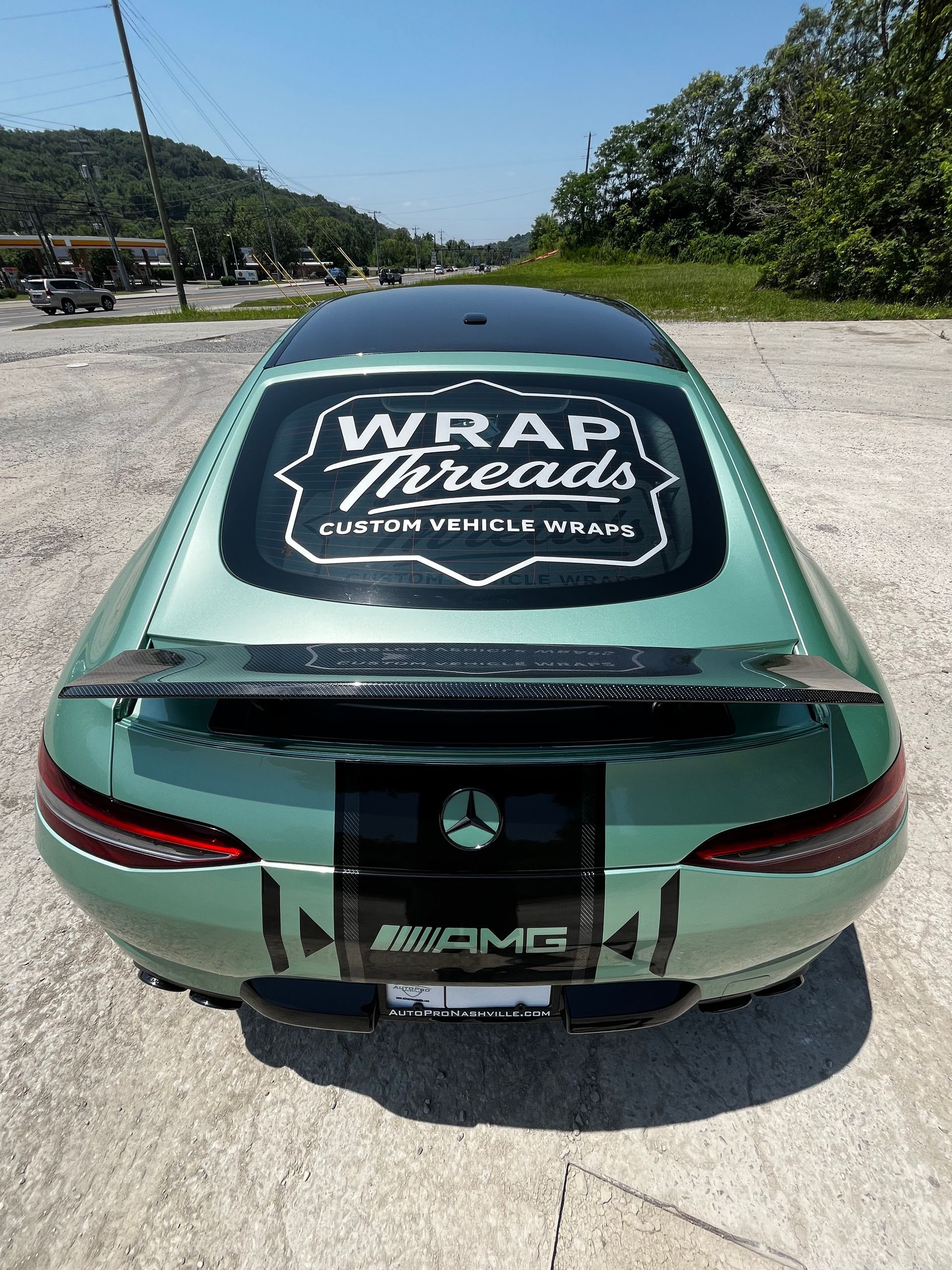 A light green Mercedes-AMG with a black rear spoiler and a 