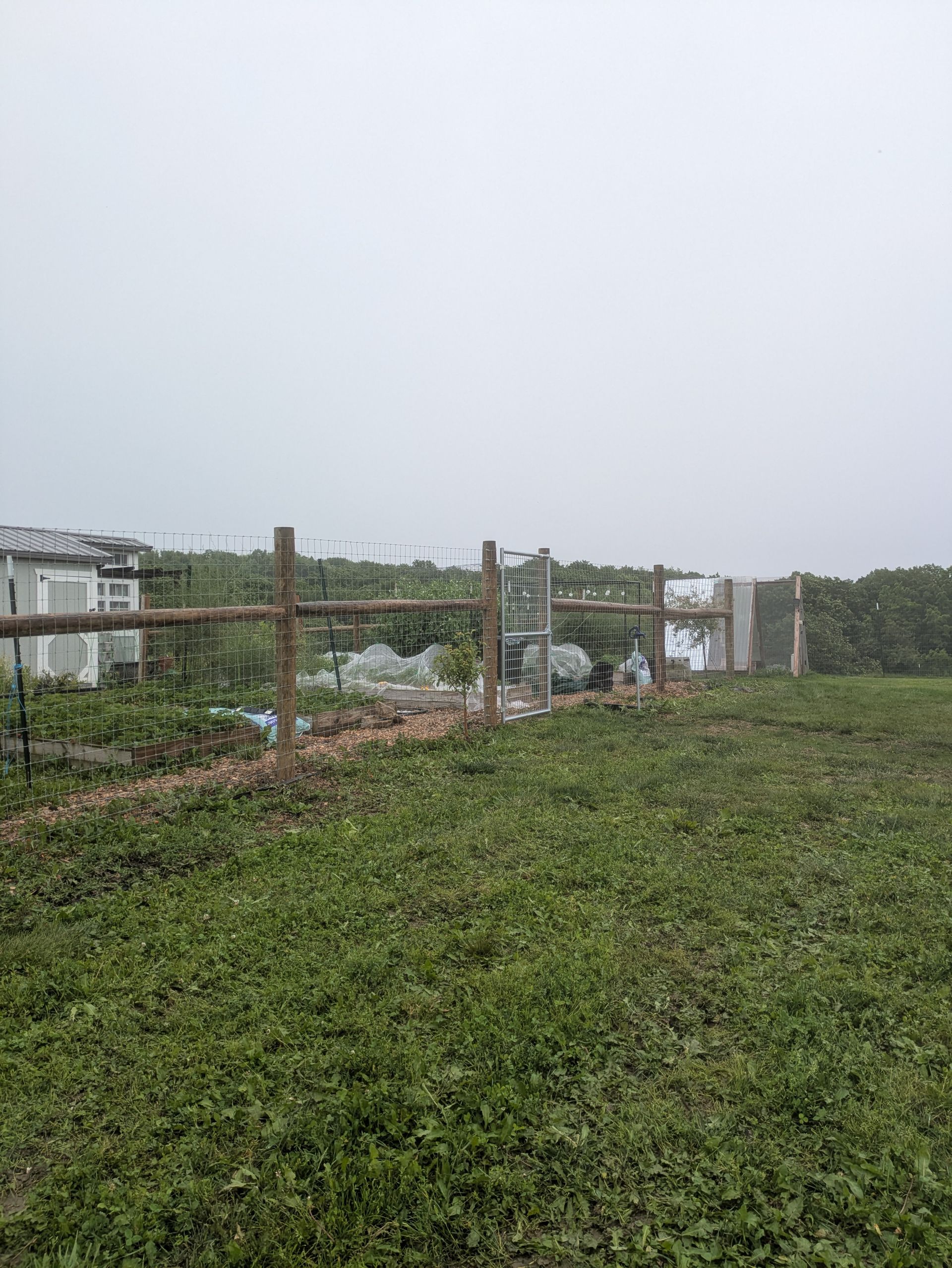 There is a wooden fence in the middle of a field.