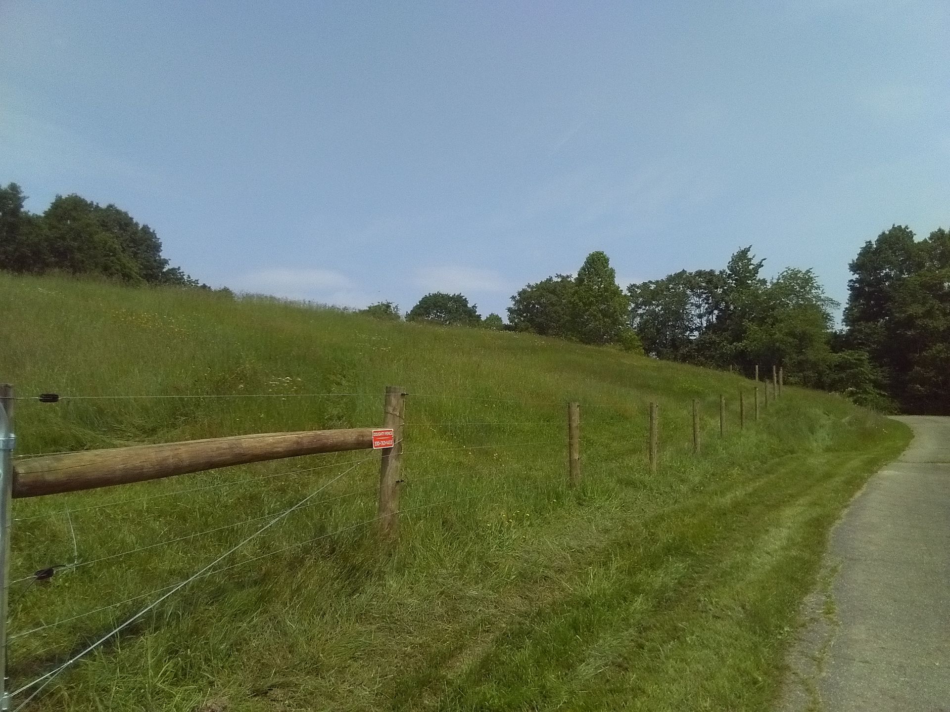 A wooden fence with a red sign on it