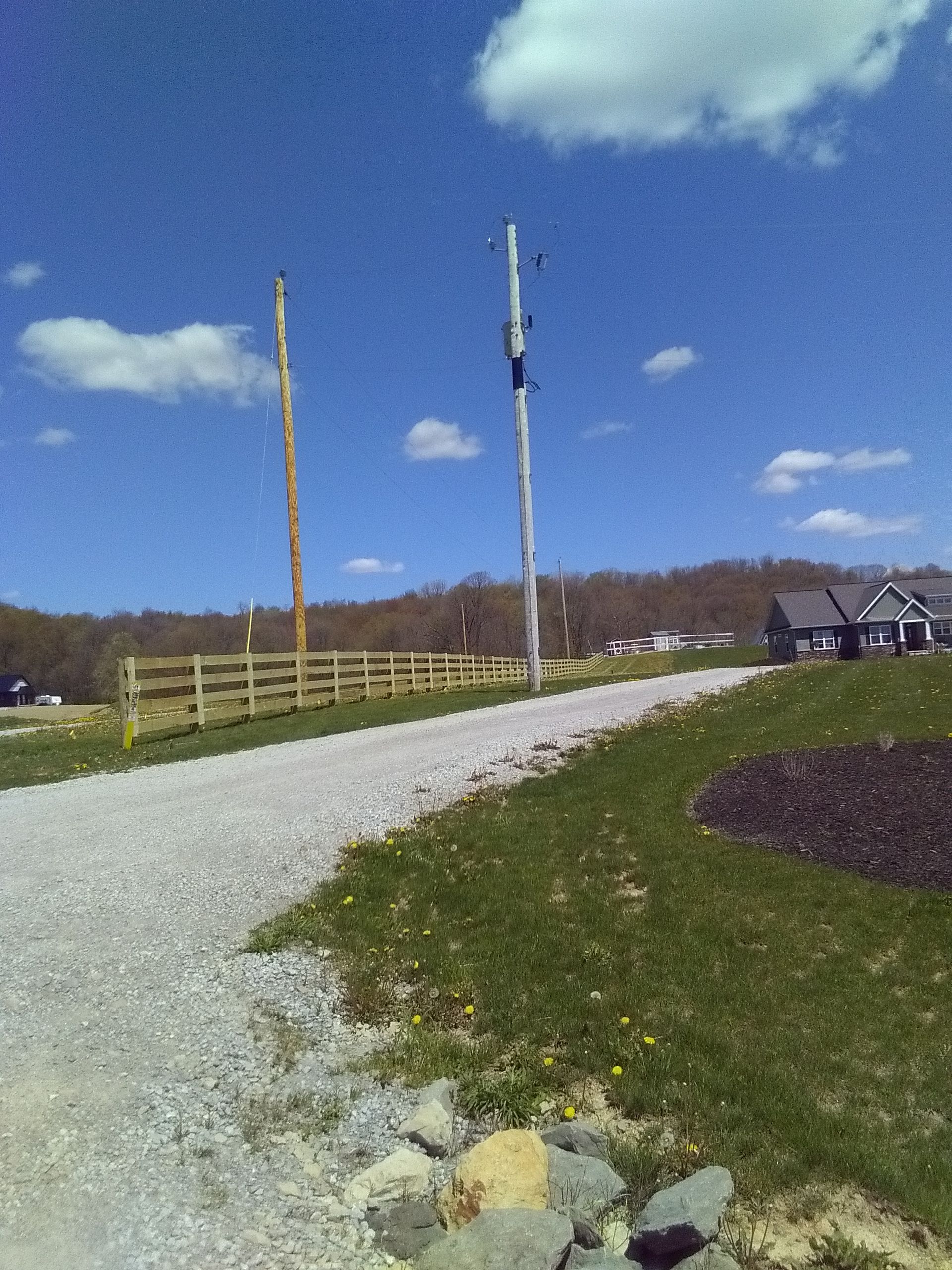 A gravel road with a fence on the side of it