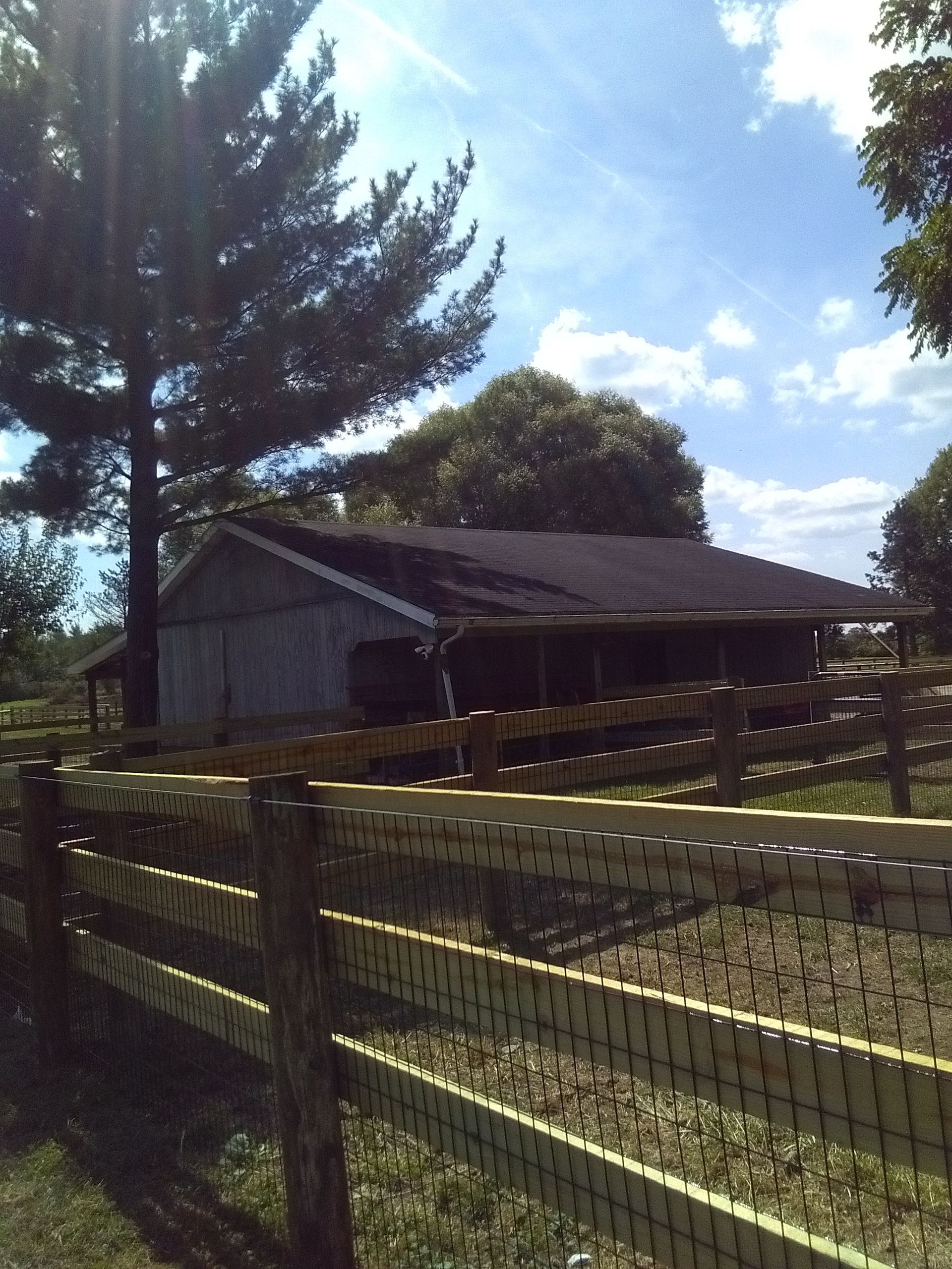 A house behind a wooden fence with trees in the background