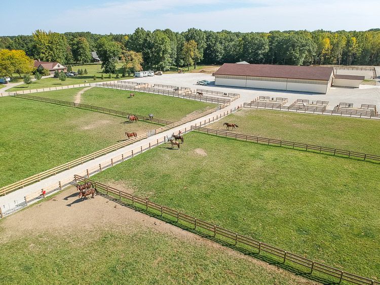 An aerial view of a horse ranch with horses and a fence.
